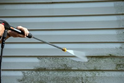 An,Unidentified,Man,Uses,A,Power,Washer,To,Clean,Mold